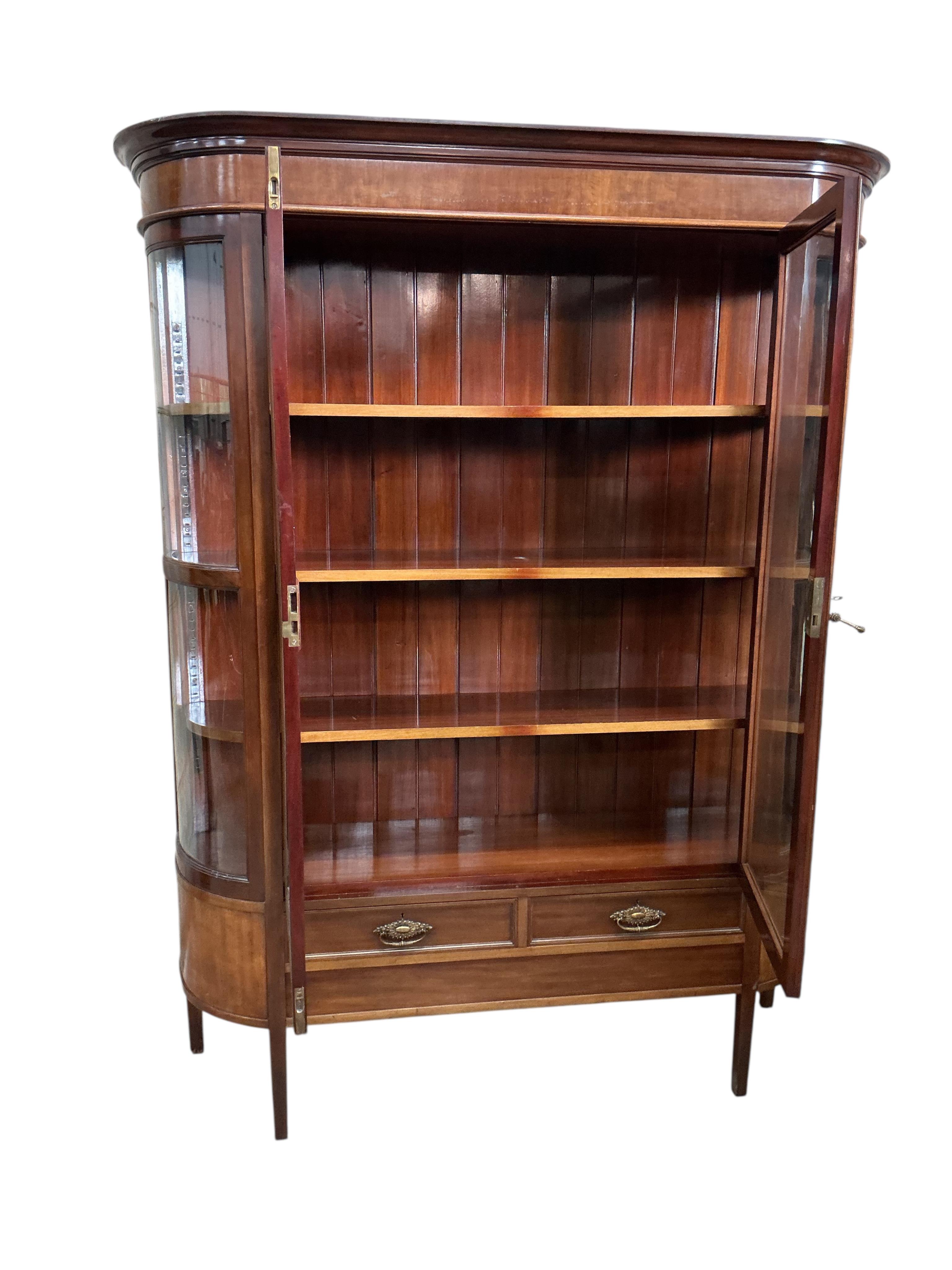 An early 20th century mahogany bookcase with two spare bow glazed door sections, width 145cm, depth 44cm, height 187cm